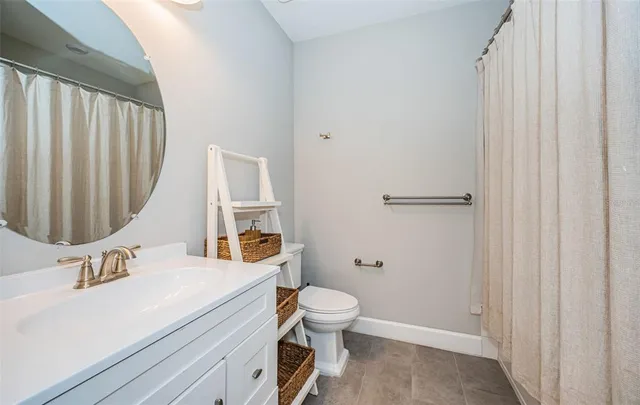 a bathroom with a sink a toilet and shower curtain