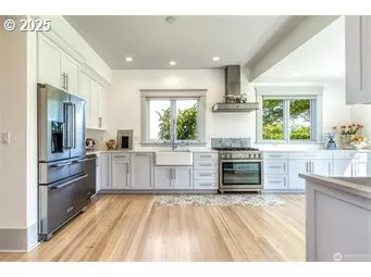a kitchen with stainless steel appliances kitchen island granite countertop a stove and a refrigerator