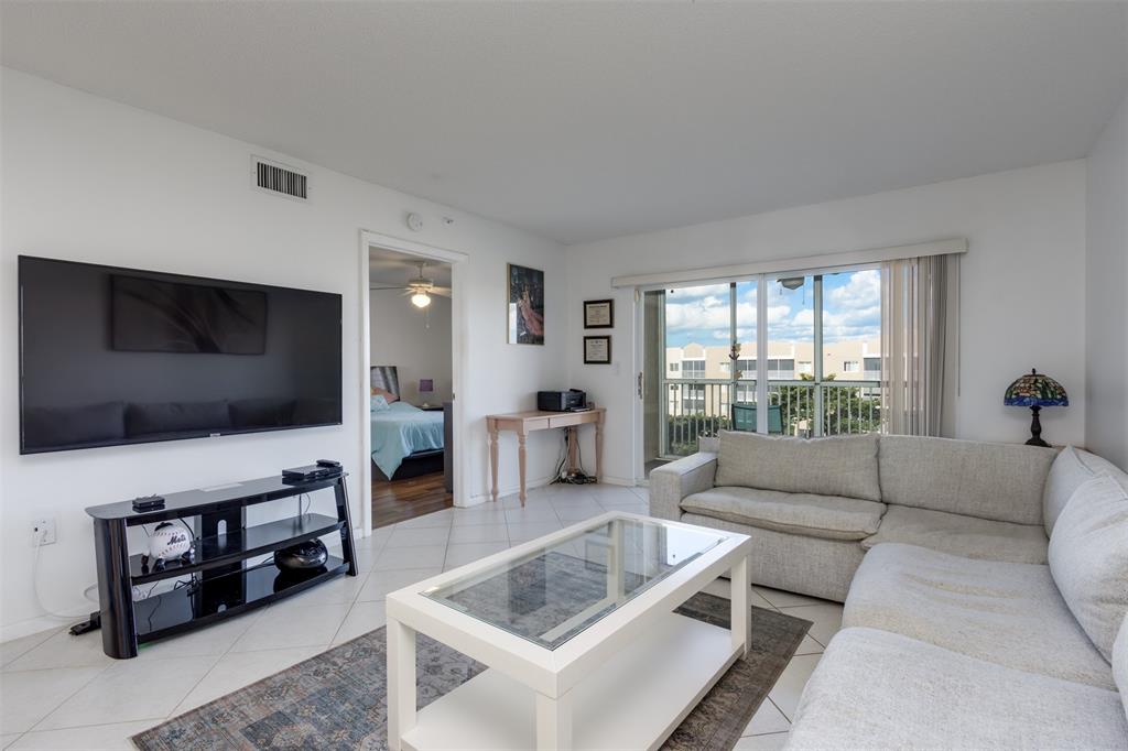 9537 Weldon Circle, Unit 404 Fort Lauderdale, FL 33321 - Photo 11 of 39 a living room with furniture and a flat screen tv