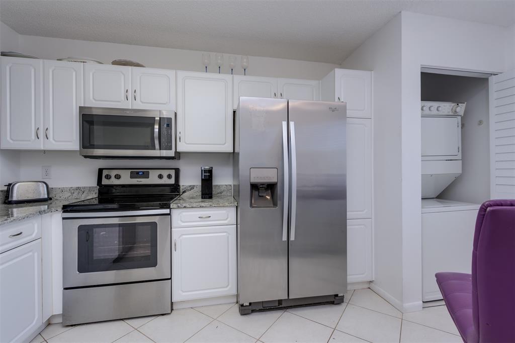 9537 Weldon Circle, Unit 404 Fort Lauderdale, FL 33321 - Photo 12 of 39 a kitchen with stainless steel appliances granite countertop a refrigerator and a stove top oven