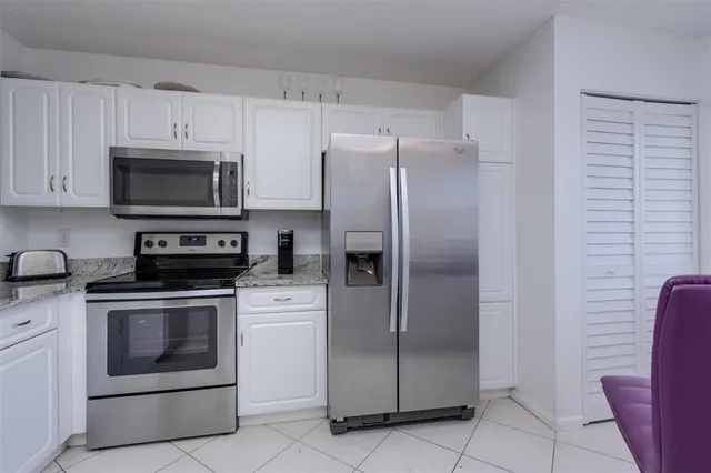a kitchen with stainless steel appliances granite countertop a refrigerator stove and sink