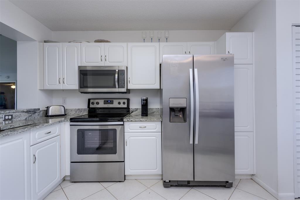 9537 Weldon Circle, Unit 404 Fort Lauderdale, FL 33321 - Photo 14 of 39 a kitchen with cabinets stainless steel appliances and a counter space