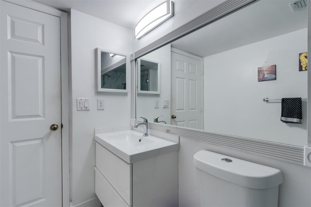 9537 Weldon Circle, Unit 404 Fort Lauderdale, FL 33321 - Photo 24 of 39 a bathroom with a sink a toilet and mirror