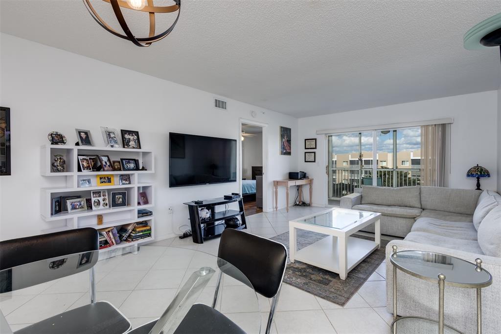 9537 Weldon Circle, Unit 404 Fort Lauderdale, FL 33321 - Photo 5 of 39 a living room with furniture and a flat screen tv