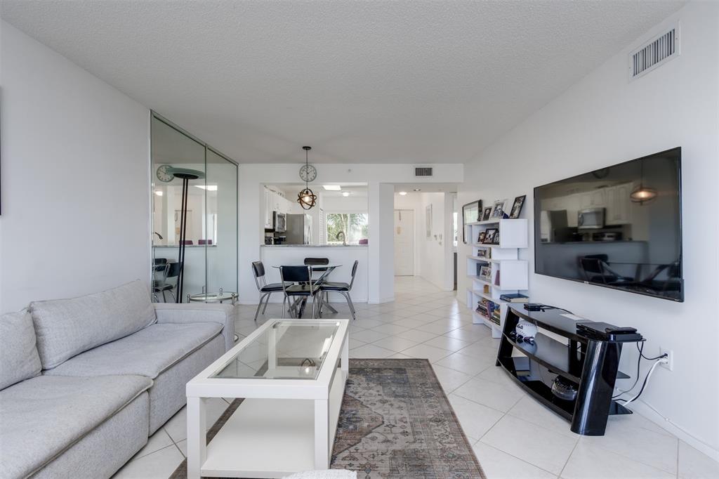 9537 Weldon Circle, Unit 404 Fort Lauderdale, FL 33321 - Photo 6 of 39 a living room with furniture and a flat screen tv
