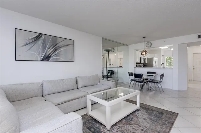 a living room with furniture and a dining table with kitchen view