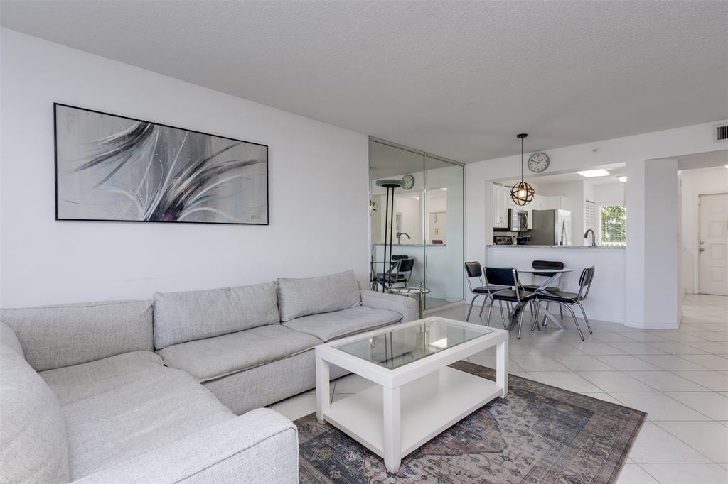 9537 Weldon Circle, Unit 404 Fort Lauderdale, FL 33321 - Photo 9 of 39 a living room with furniture and a dining table with kitchen view