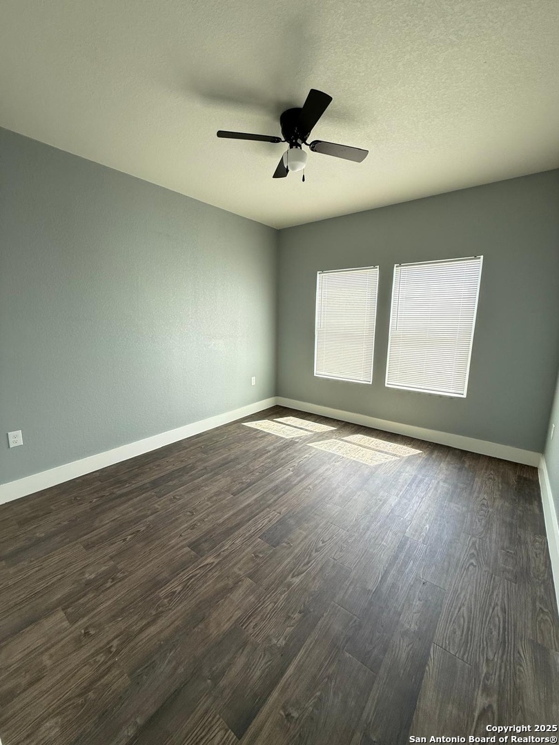 802 Cr 520 D'Hanis, TX 78850 - Photo 12 of 33 an empty room with wooden floor and windows