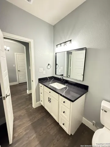 a bathroom with a double vanity sink and mirror with toilet