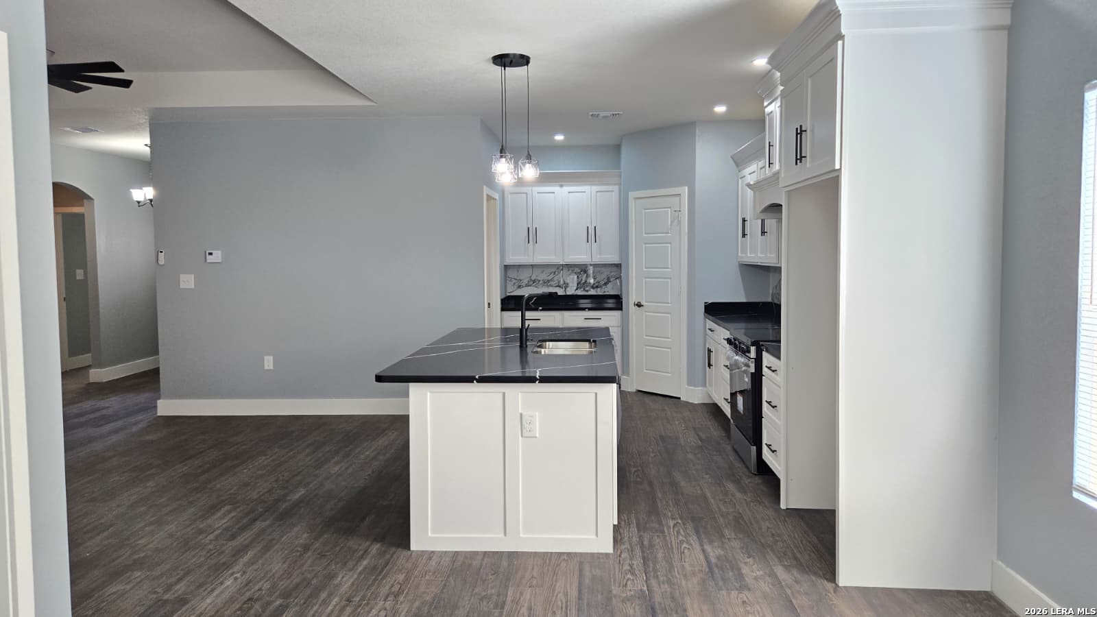 802 Cr 520 D'Hanis, TX 78850 - Photo 22 of 33 an empty room with wooden floor and a kitchen