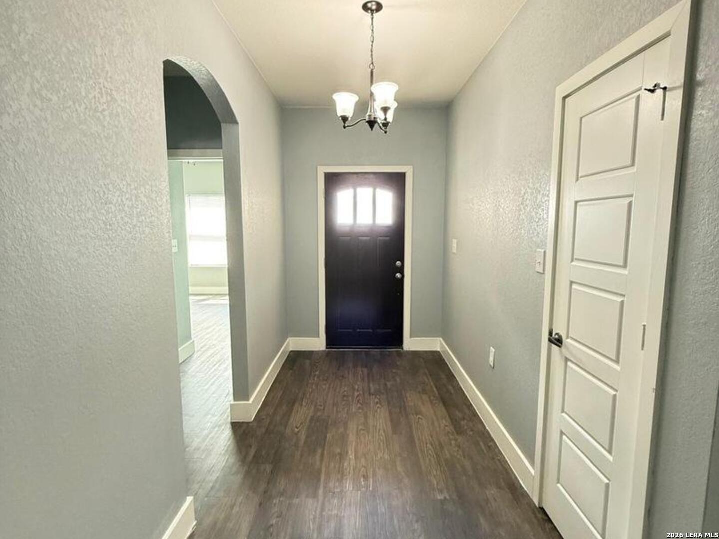 802 Cr 520 D'Hanis, TX 78850 - Photo 4 of 33 a view of a hallway with wooden floor and a chandelier