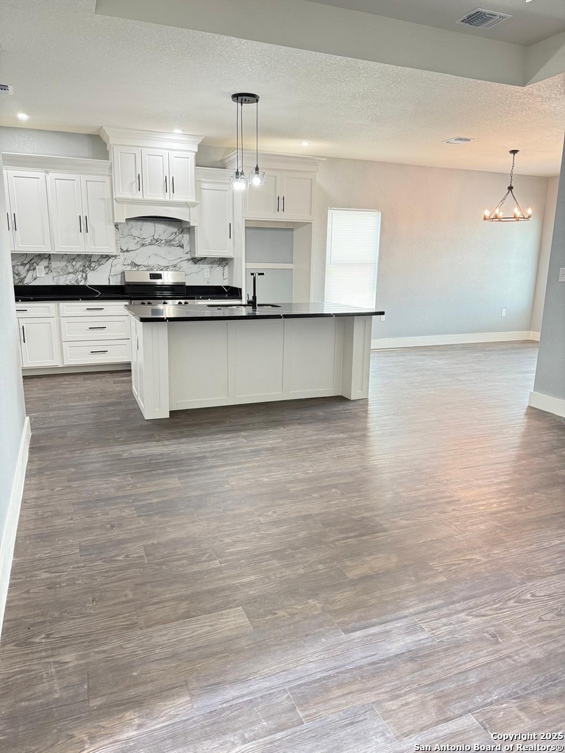 802 Cr 520 D'Hanis, TX 78850 - Photo 5 of 16 a large kitchen with granite countertop a sink a counter space and cabinets