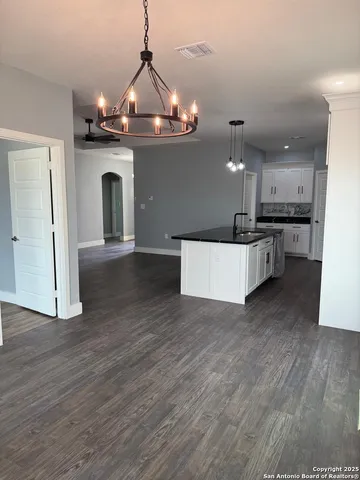 a view of a kitchen with a sink wooden floor and a refrigerator