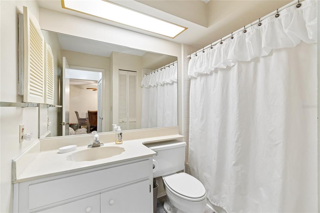 11340 Carriage Hill Drive, Unit 4 Port Richey, FL 34668 - Photo 11 of 36 a bathroom with a sink a toilet and shower curtain