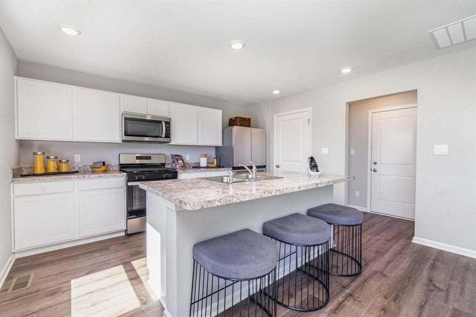 615 Ensign Place Hebron, IN 46341 - Photo 14 of 29 a kitchen with kitchen island granite countertop a sink and a refrigerator