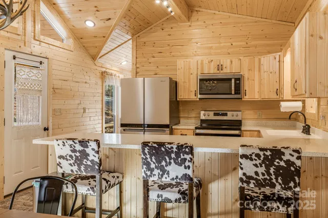 a kitchen with stainless steel appliances a sink a stove top oven a counter space and cabinets