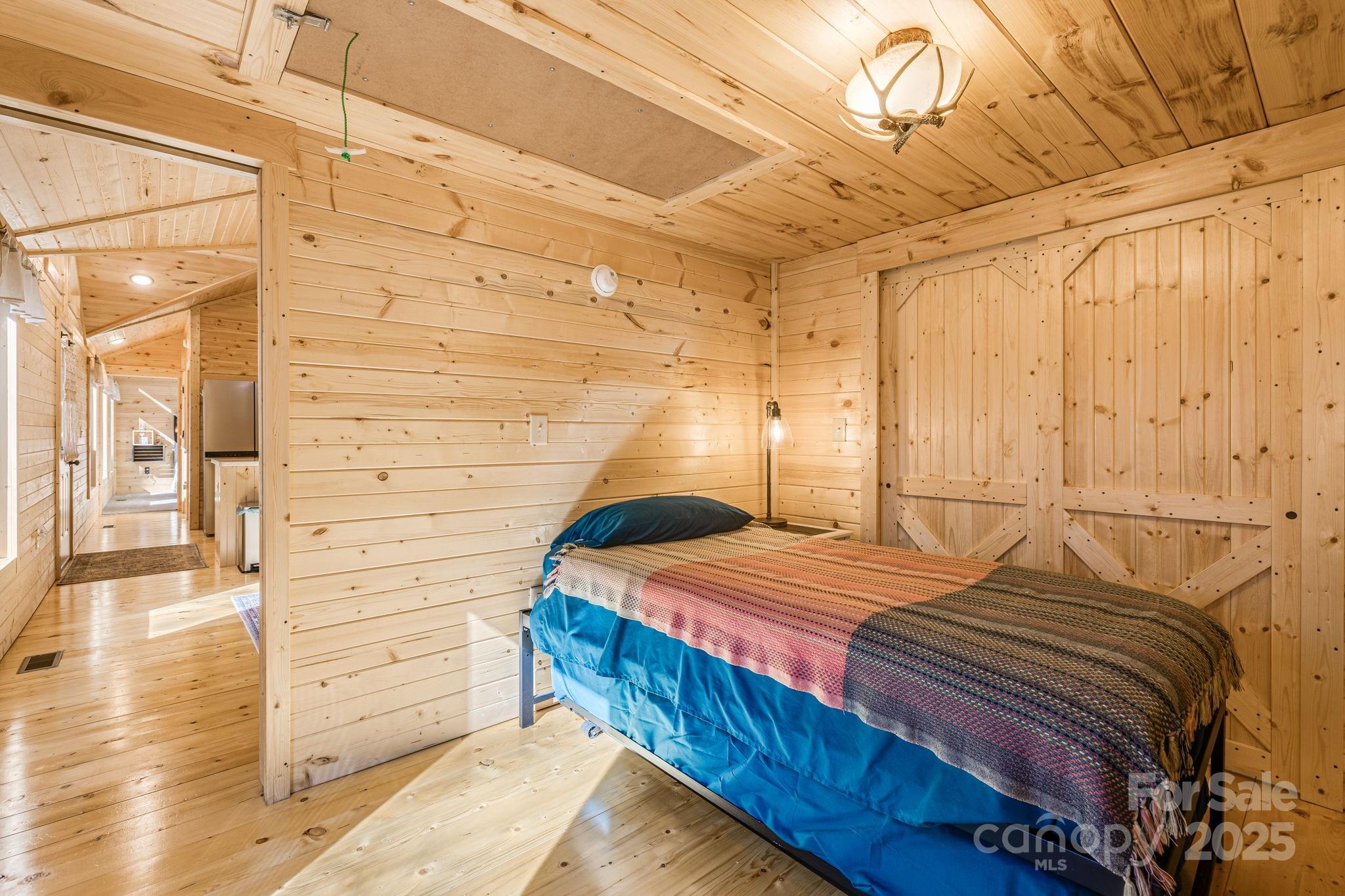 81 Delind Drive Mill Spring, NC 28756 - Photo 24 of 40 a bedroom with a bed and wooden floor