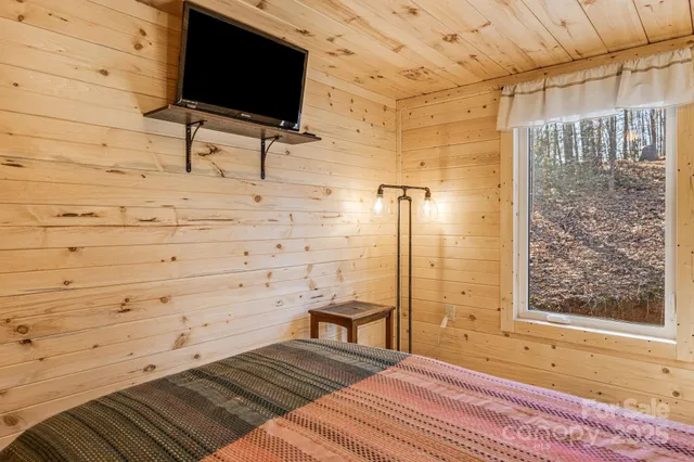 a bedroom with a bed and a flat screen tv