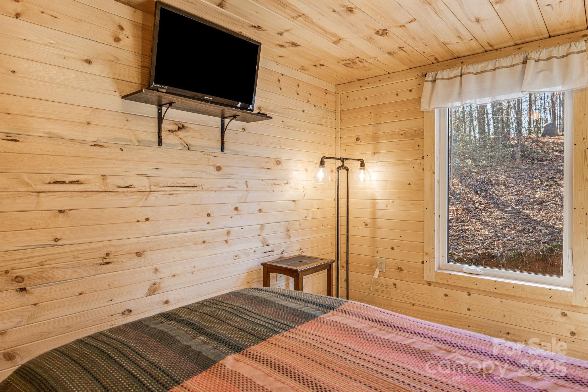 81 Delind Drive Mill Spring, NC 28756 - Photo 25 of 40 a bedroom with a bed and a flat screen tv