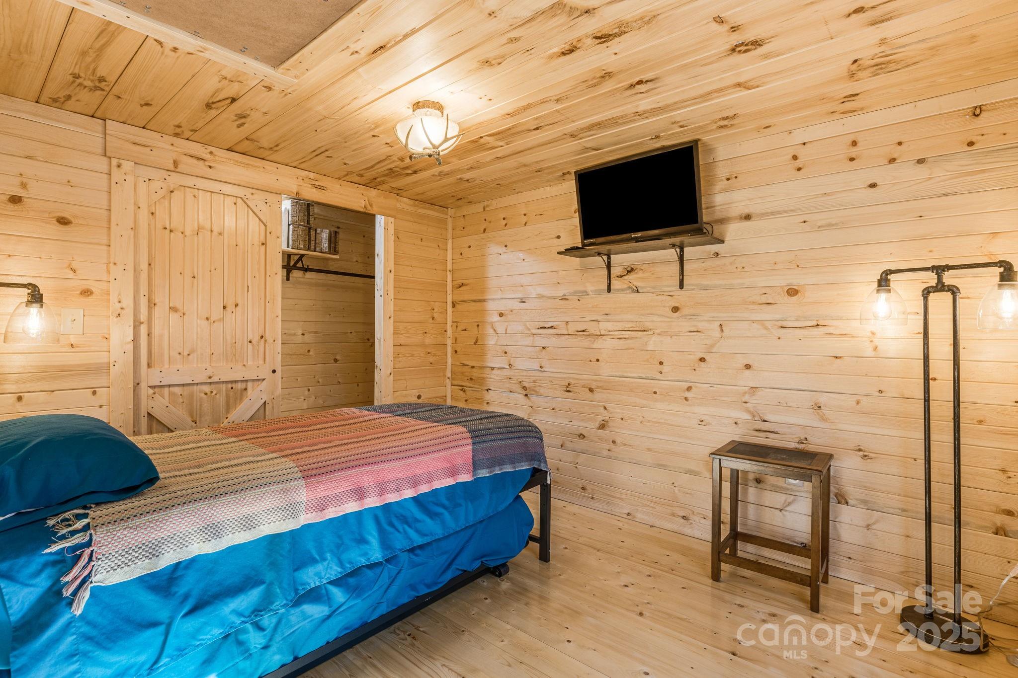 81 Delind Drive Mill Spring, NC 28756 - Photo 26 of 40 a bedroom with a bed and a flat screen tv