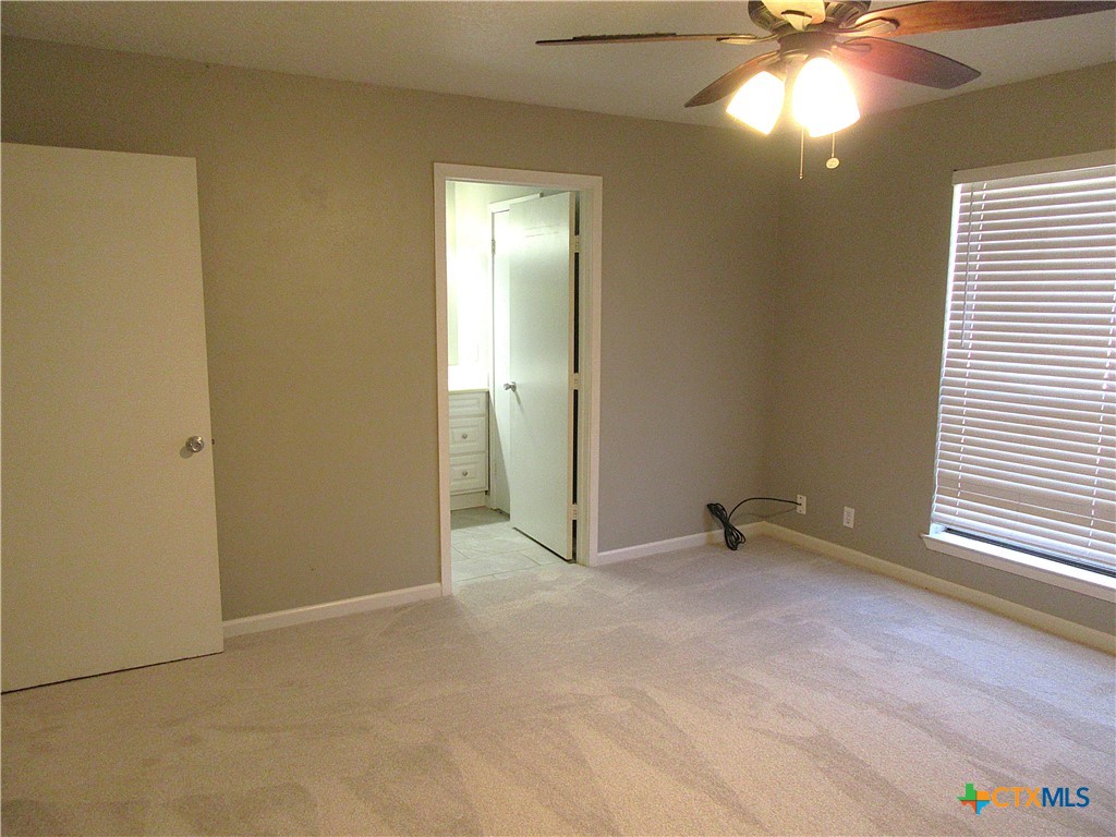 4113 Fox Trail Temple, TX 76504 - Photo 15 of 30 an empty room with windows and chandelier fan