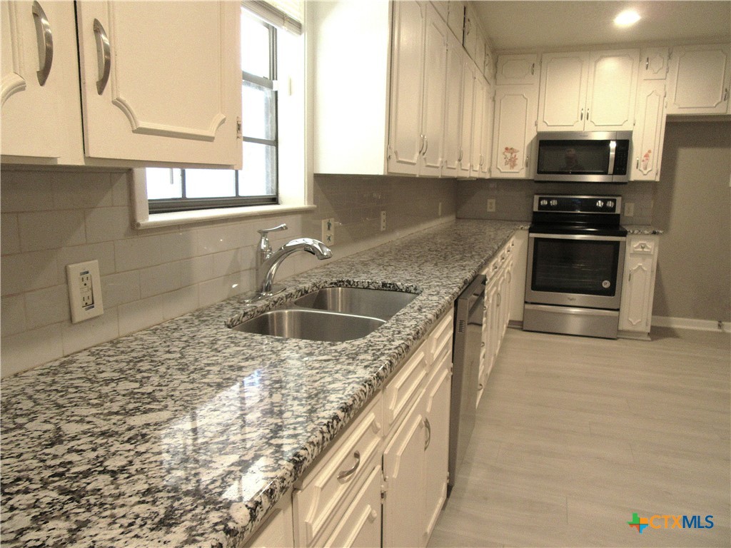 4113 Fox Trail Temple, TX 76504 - Photo 7 of 30 a kitchen with stainless steel appliances granite countertop a sink stove and refrigerator