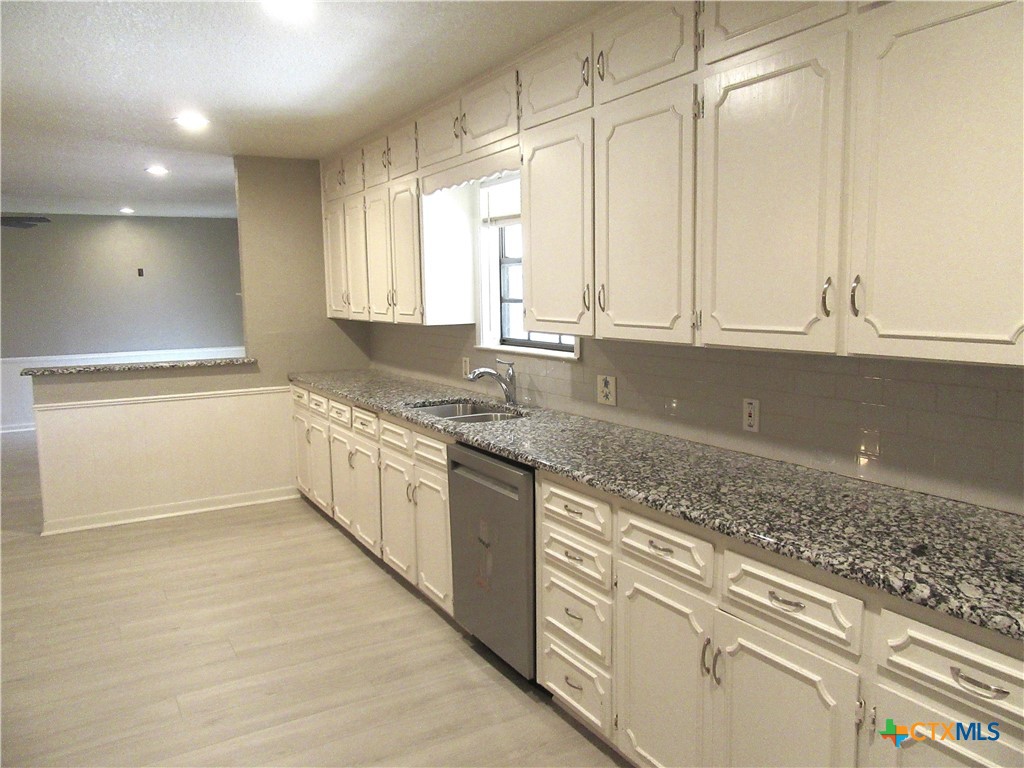 4113 Fox Trail Temple, TX 76504 - Photo 8 of 30 a kitchen with granite countertop white cabinets and white appliances
