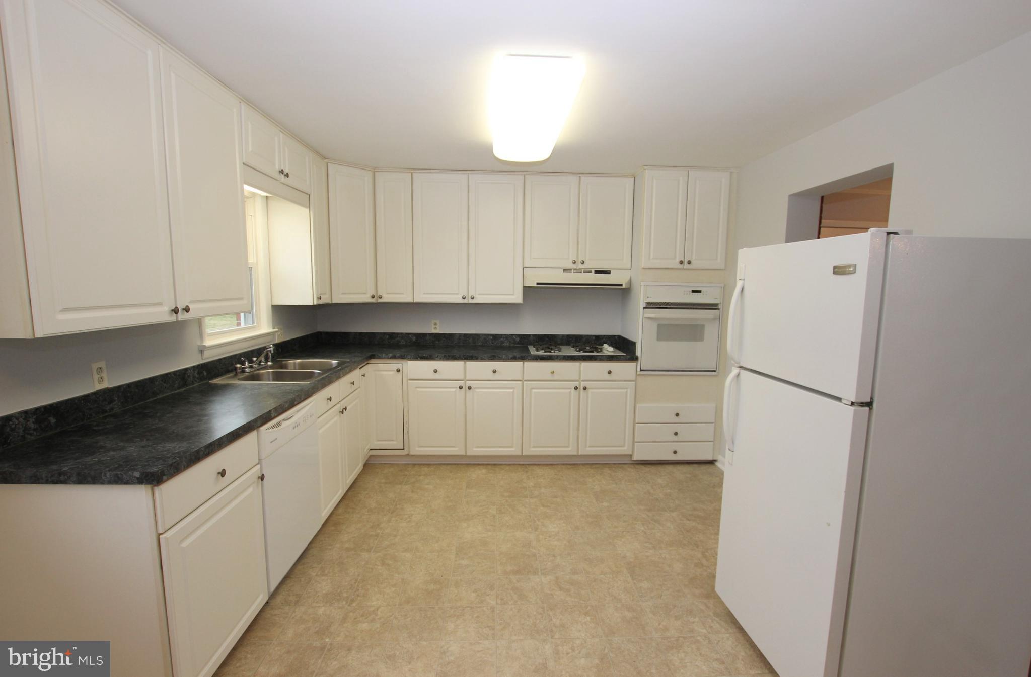 48 Apex Circle Ranson, WV 25438 - Photo 11 of 24 a kitchen with white cabinets and white appliances