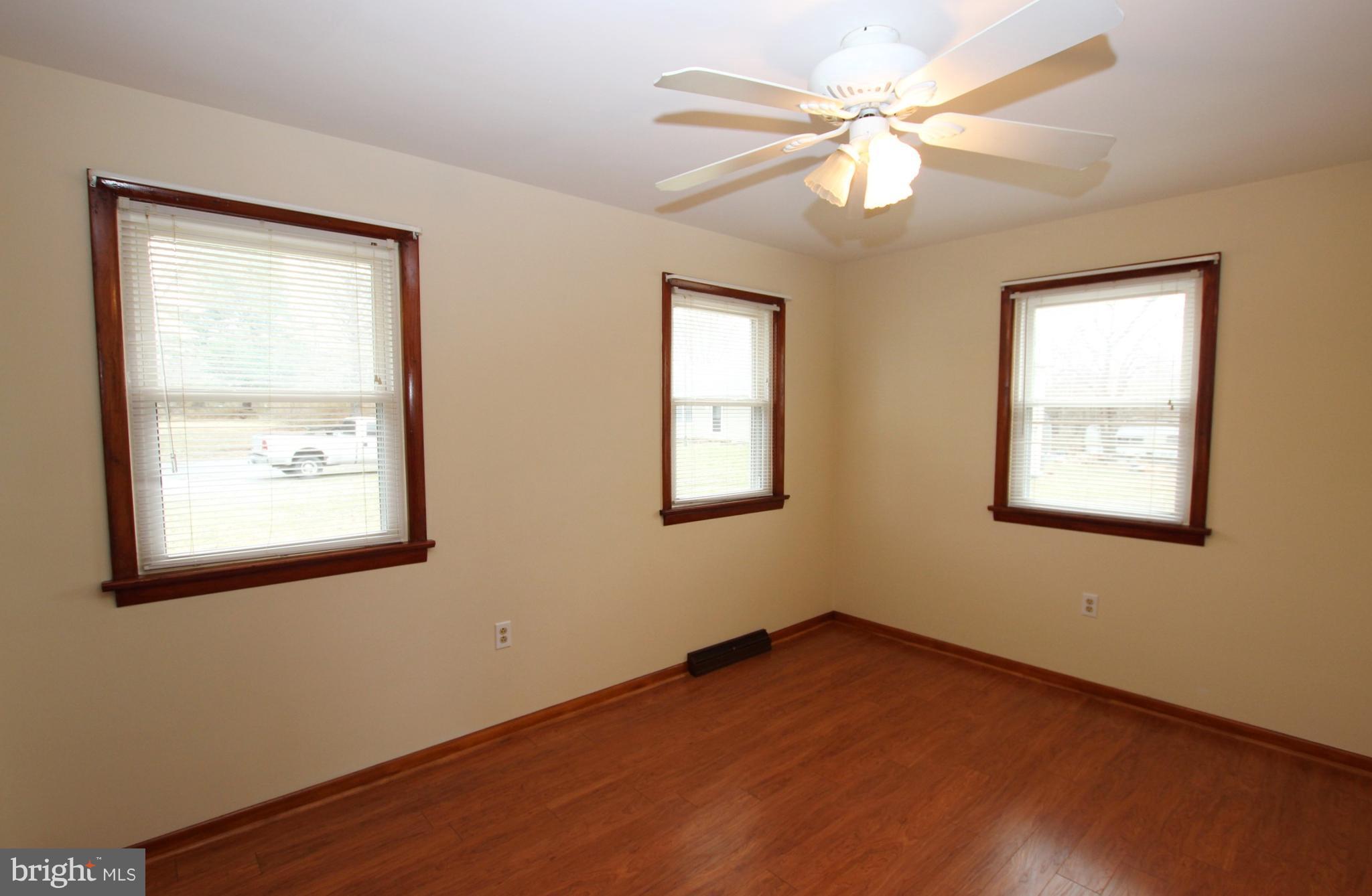 48 Apex Circle Ranson, WV 25438 - Photo 18 of 24 an empty room with wooden floor chandelier fan and windows