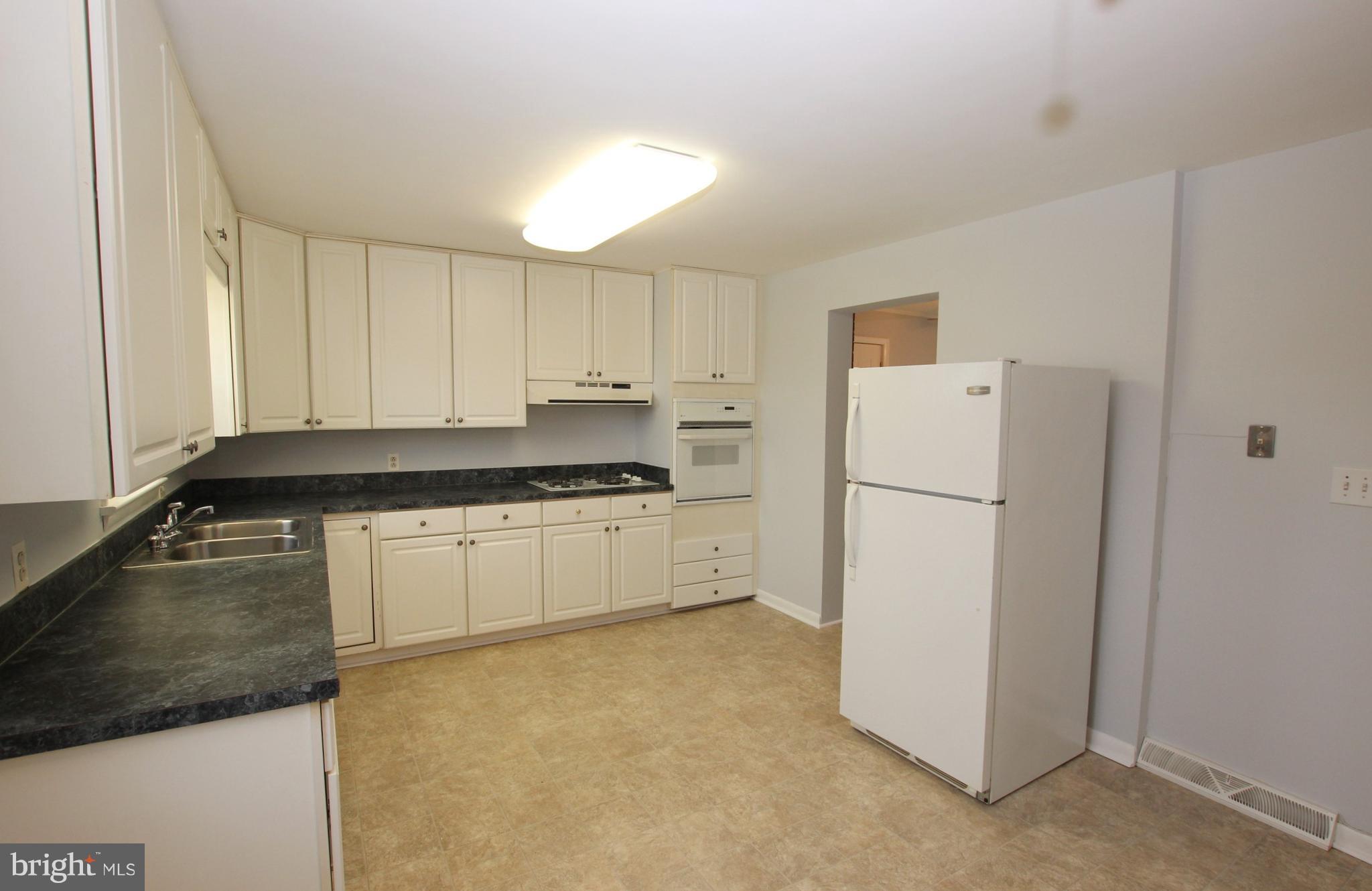 48 Apex Circle Ranson, WV 25438 - Photo 8 of 24 a kitchen with a refrigerator a stove and white cabinets