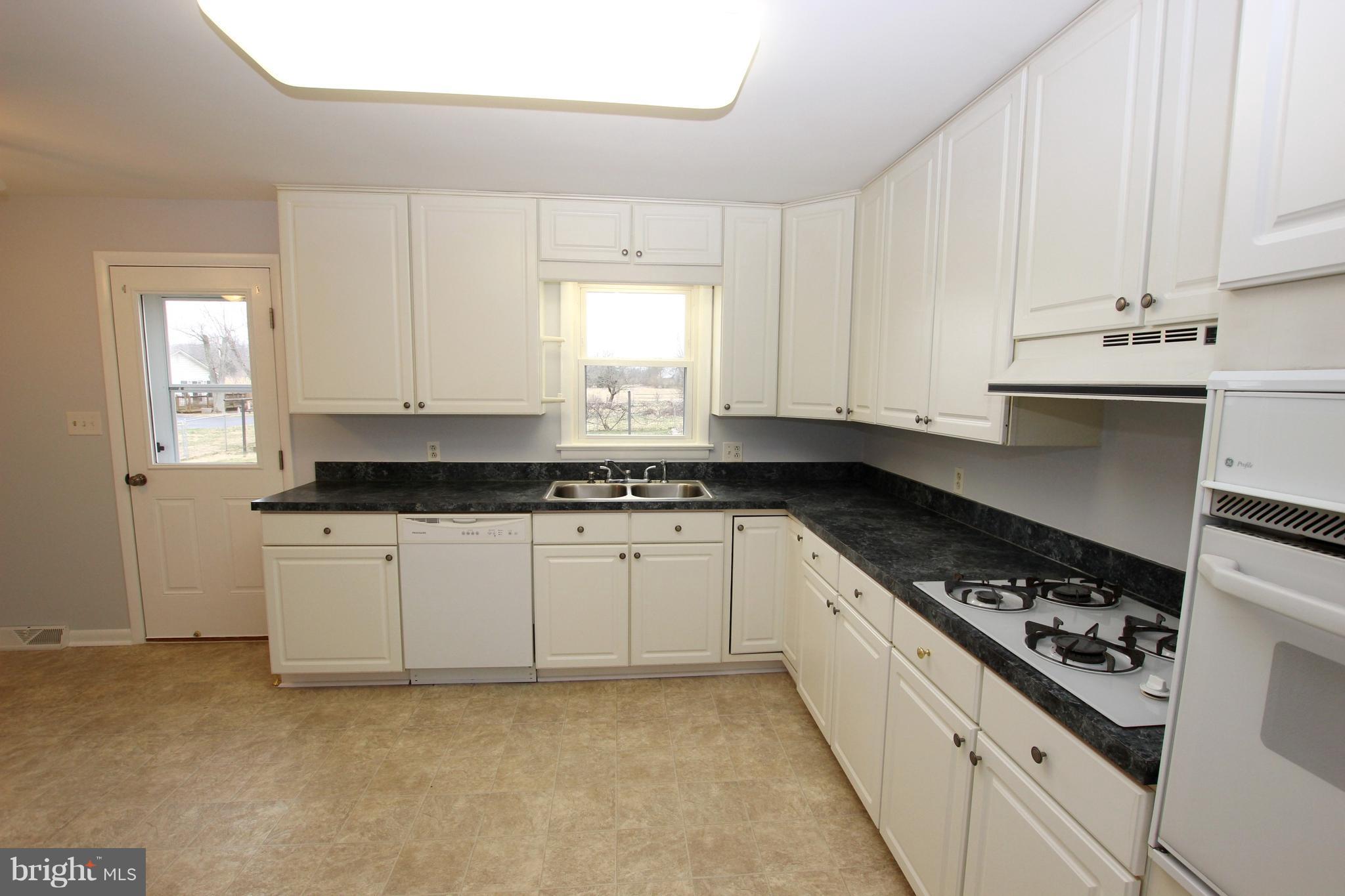 48 Apex Circle Ranson, WV 25438 - Photo 10 of 24 a kitchen with granite countertop white cabinets and white appliances