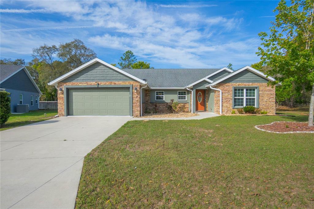 5466 West Tortuga Loop Lecanto, FL 34461 - Photo 1 of 41 a view of a house with a yard and garage