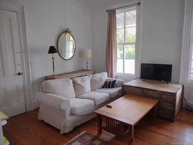 a living room with furniture and a mirror