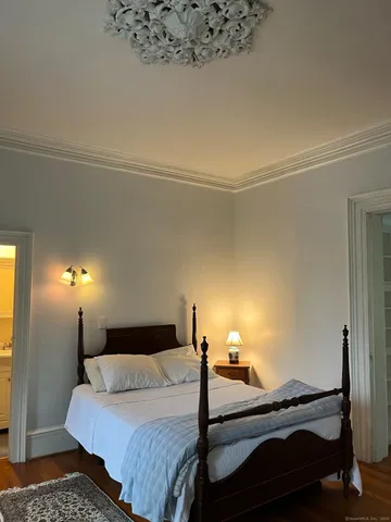 a bedroom with a bed and a lamp on the dresser