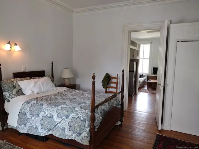 a bedroom with a bed and wooden floor