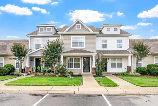 a front view of a house with a yard and potted plants