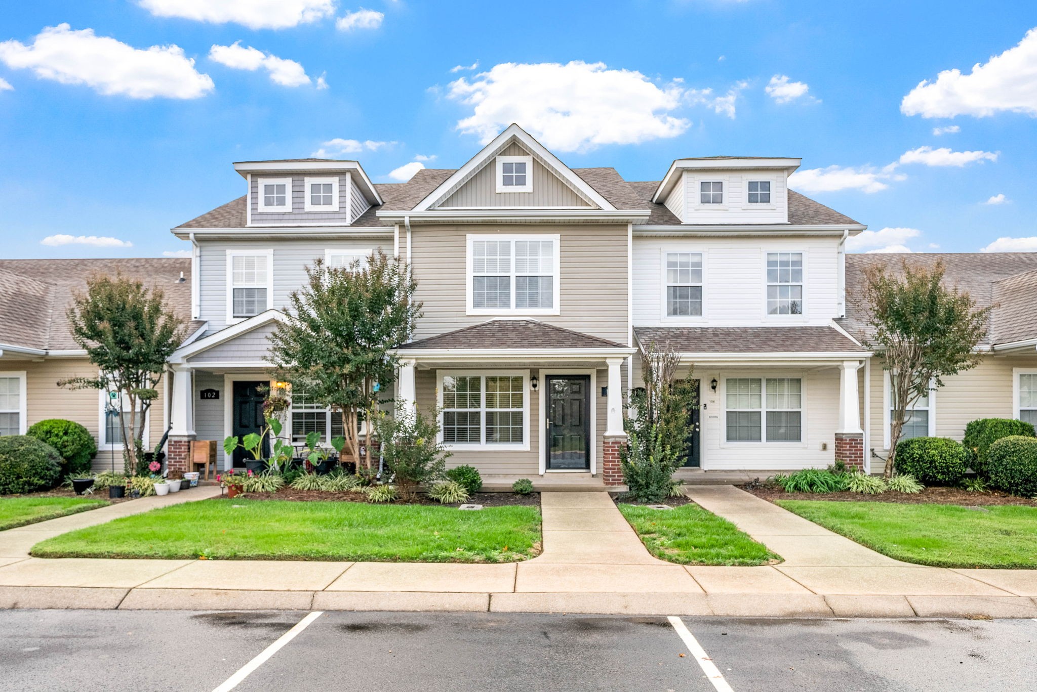 a front view of a house with a yard and potted plants