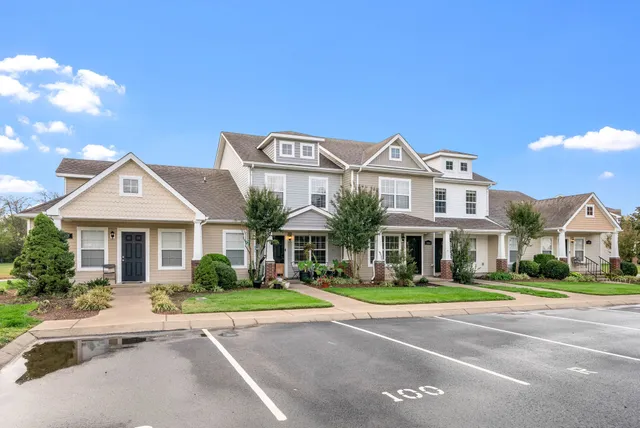 a front view of residential houses with yard and green space
