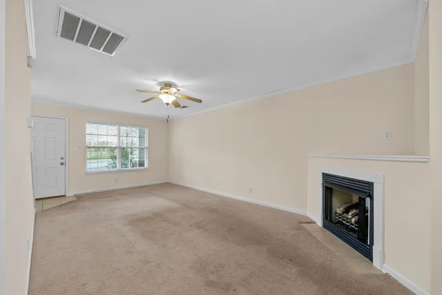 an empty room with a fireplace and windows