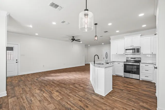 a kitchen with granite countertop a stove and a sink