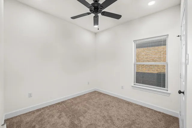 an empty room with chandelier fan