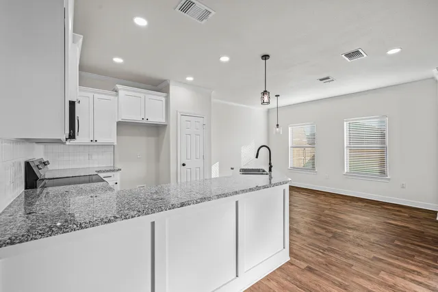 a kitchen with a sink window and cabinets