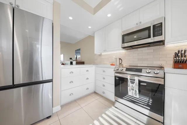 a kitchen with stainless steel appliances granite countertop a refrigerator a stove a sink and a microwave