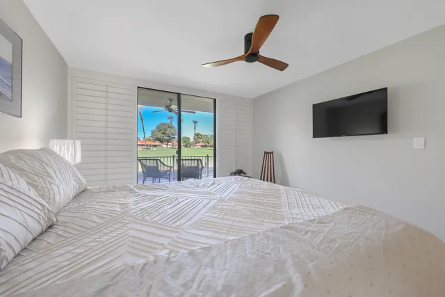 a bedroom with a large bed and a flat screen tv