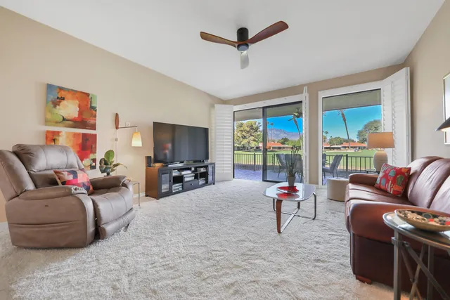 a living room with furniture ceiling fan and a flat screen tv