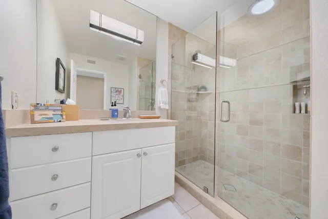 a bathroom with a shower sink and mirror