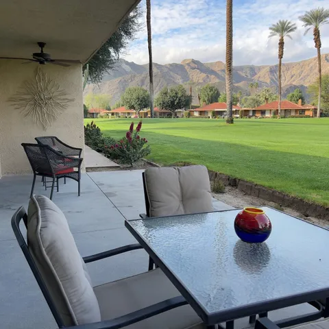 a view of a big house with a big yard and large trees