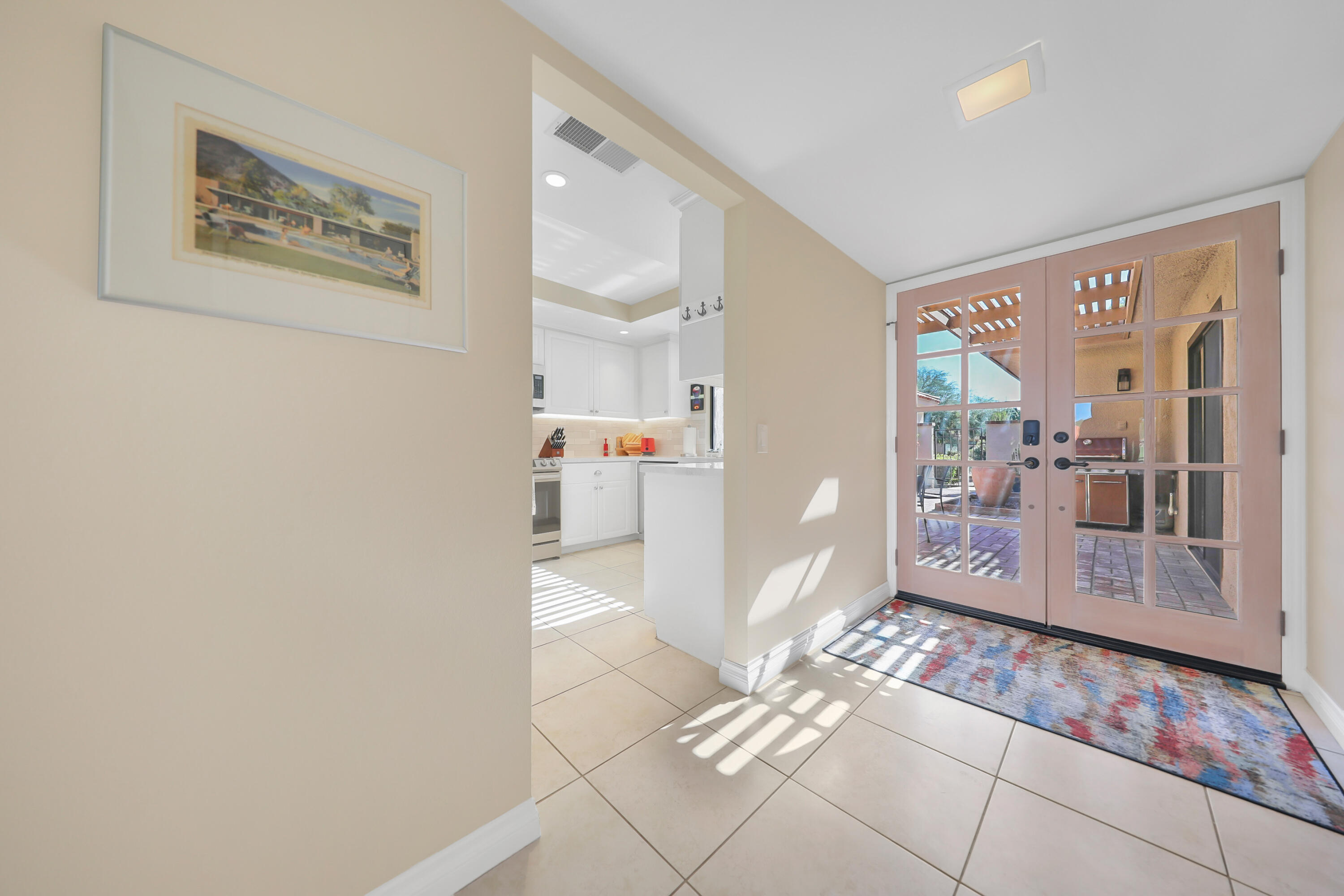 48 Palma Drive Rancho Mirage, CA 92270 - Photo 7 of 52 a view of a hallway with wooden floor and a living room