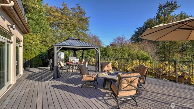 a view of a patio with table and chairs under an umbrella with wooden floor