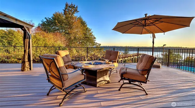 a view of a roof deck with table and chairs under an umbrella with wooden floor
